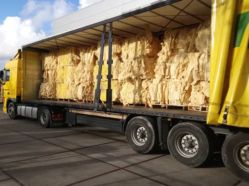 Vrachtwagen met balen glaswolresten